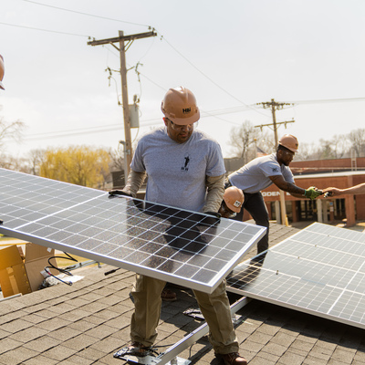 Soldiers from Fort Riley's HBI Program install solar panels on the home build at 203 South Elm Street.
