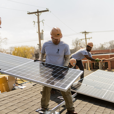 Soldiers from Fort Riley's HBI Program install solar panels on the home build at 203 South Elm Street.